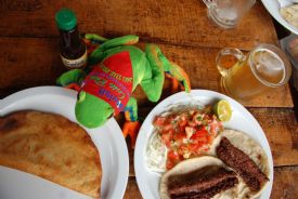 Javi the Frog about to dig into an empanada with a beer
