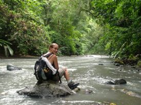 Hiker sitting on rock in river at Corcovado National Park