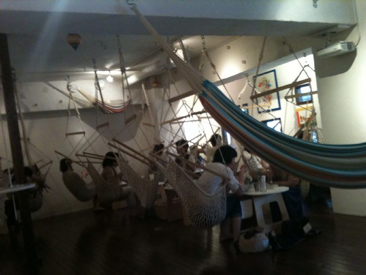 Sitting in hammocks at the Mahika Mano Cafe in Tokyo, Japan