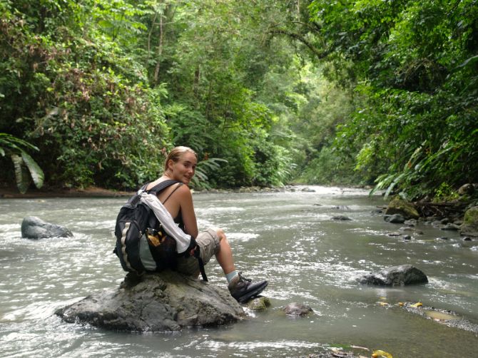 Hiker sitting on rock in river at Corcovado National Park
