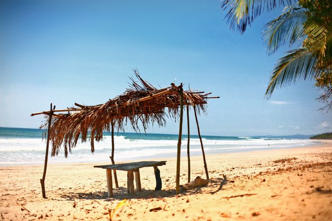 Palm thatched roof in front of the surf break at Santa Teresa