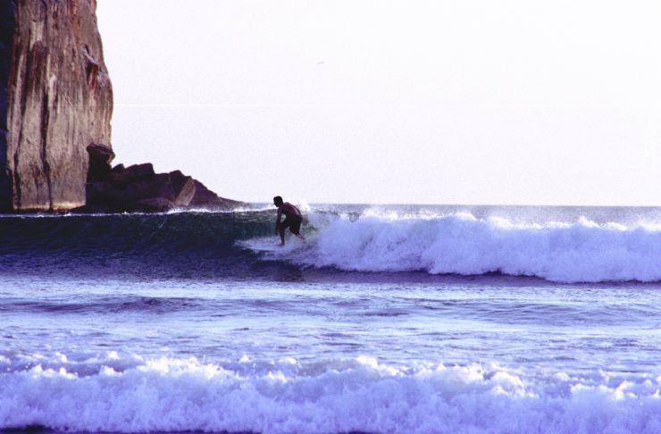 Surfer on the right wave at the famous Witch's Rock in Santa Rosa National Park