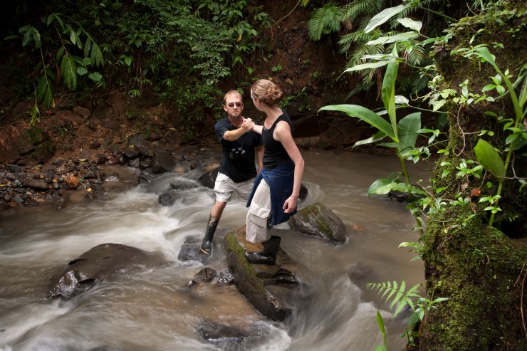 Couple crossing the Rio Bonita near La Gamba