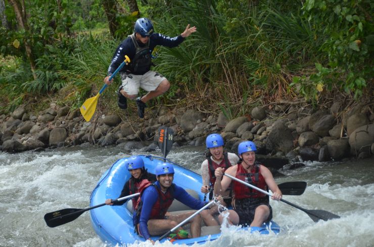 Guide jumping on boat on white water rapids