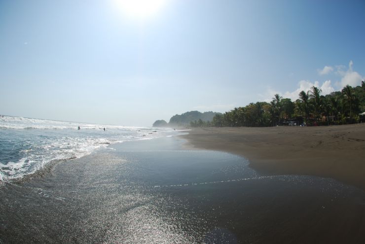 Sunny black sand beach at Playa Hermosa