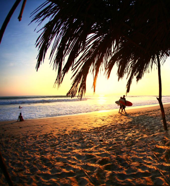 Surfers walking back from great surf in Santa Teresa