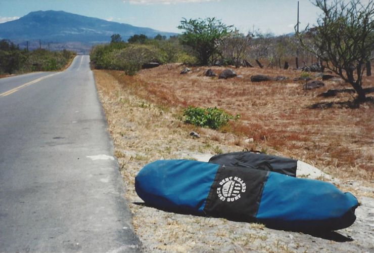 Waiting to take the bus with a surfboard after camping in front of Witches Rock surf spot in Santa Rosa National Park