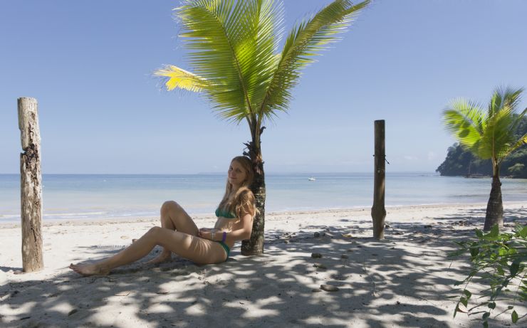Girl leaning on a post on the beautiful Punta Leona beach