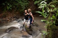 Couple crossing the Rio Bonita near La Gamba